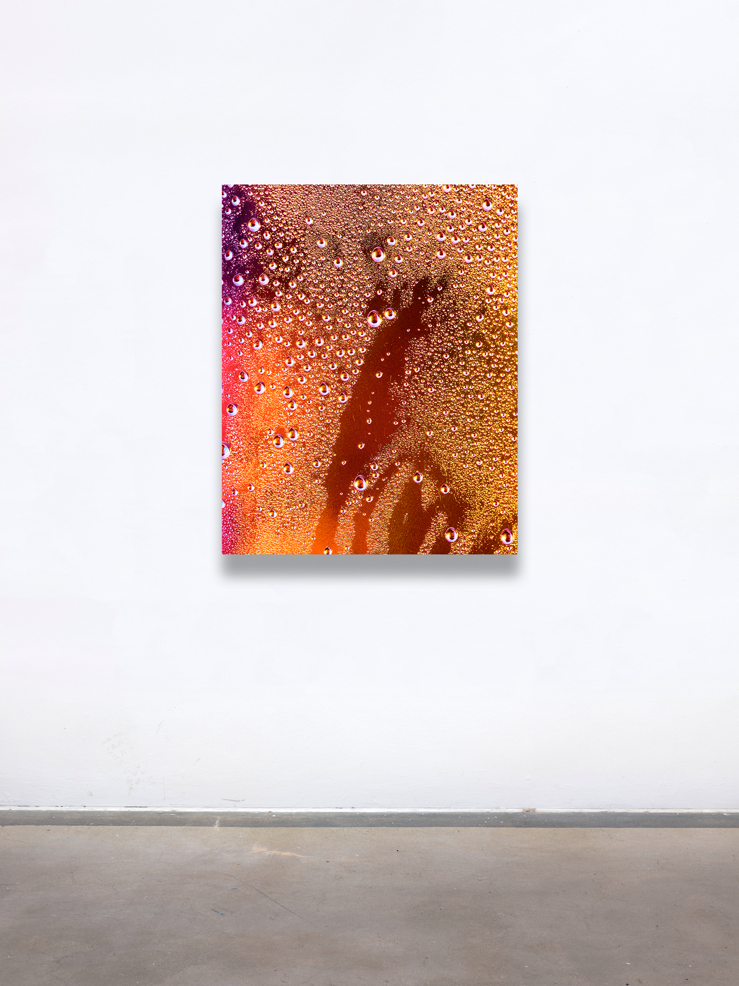Joel Dixon, a graduate artist in the UK captures a close-up of condensation droplets on a glass surface, where vibrant orange and yellow lighting create an abstract pattern. This mesmerizing piece is part of the graduate artworks for sale by The Graduate Gallery.