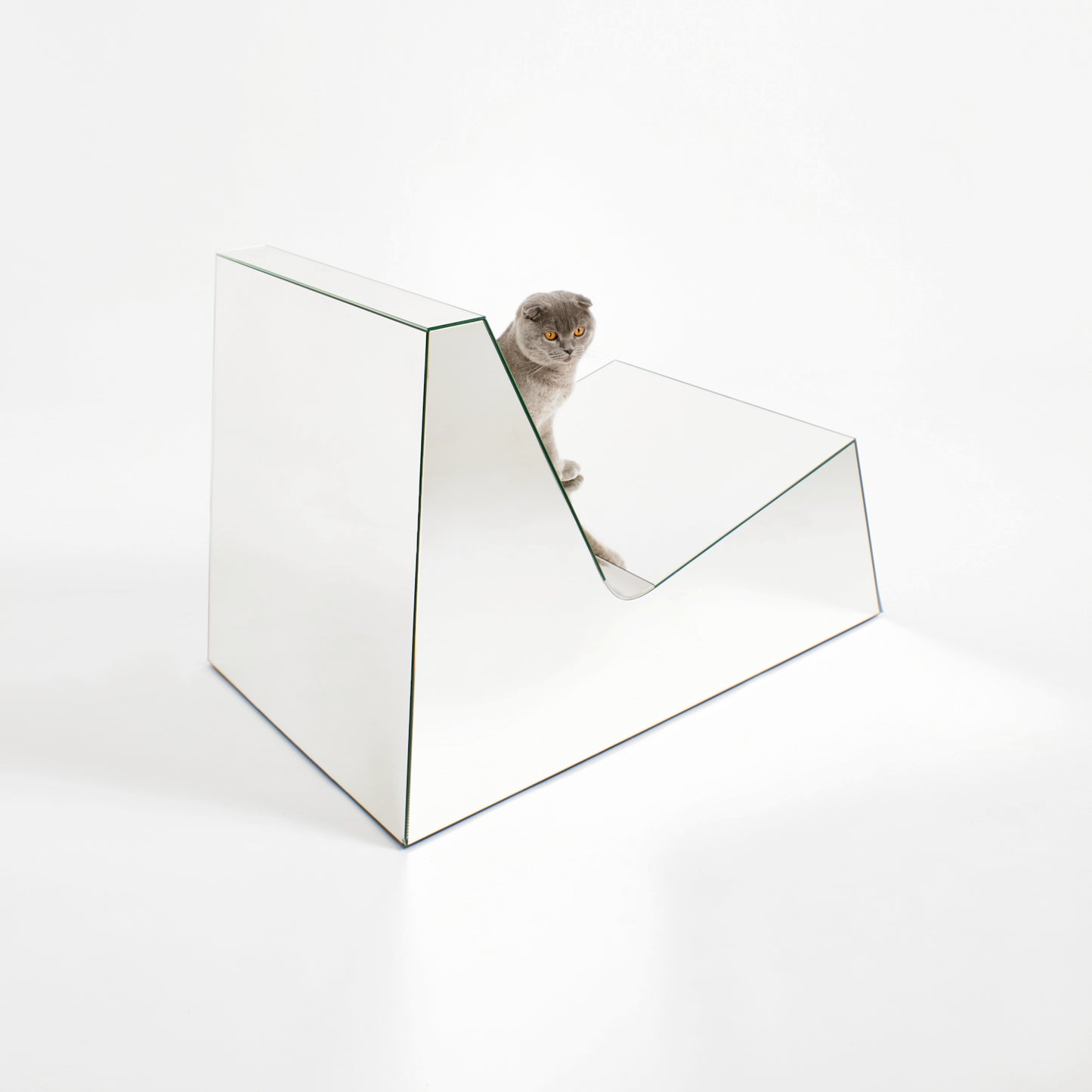 Discover a modern chair with a minimalist design, featuring a reflective mirror surface. Its angular shape creates a geometric aesthetic, set against a plain white background. This stunning piece of furniture is available for sale by The Graduate Gallery.