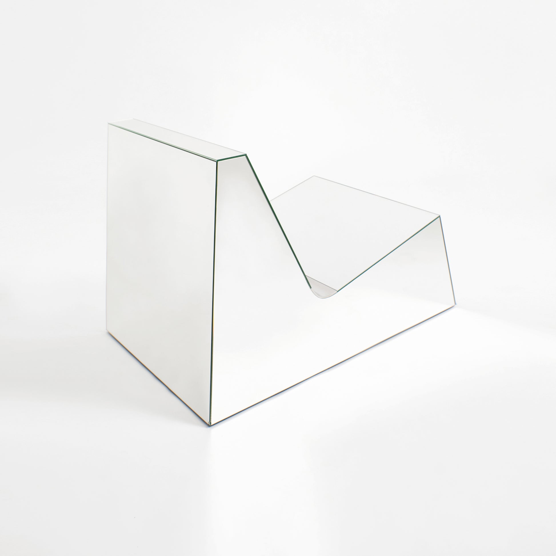 Discover a modern chair with a minimalist design, featuring a reflective mirror surface. Its angular shape creates a geometric aesthetic, set against a plain white background. This stunning piece of furniture is available for sale by The Graduate Gallery.