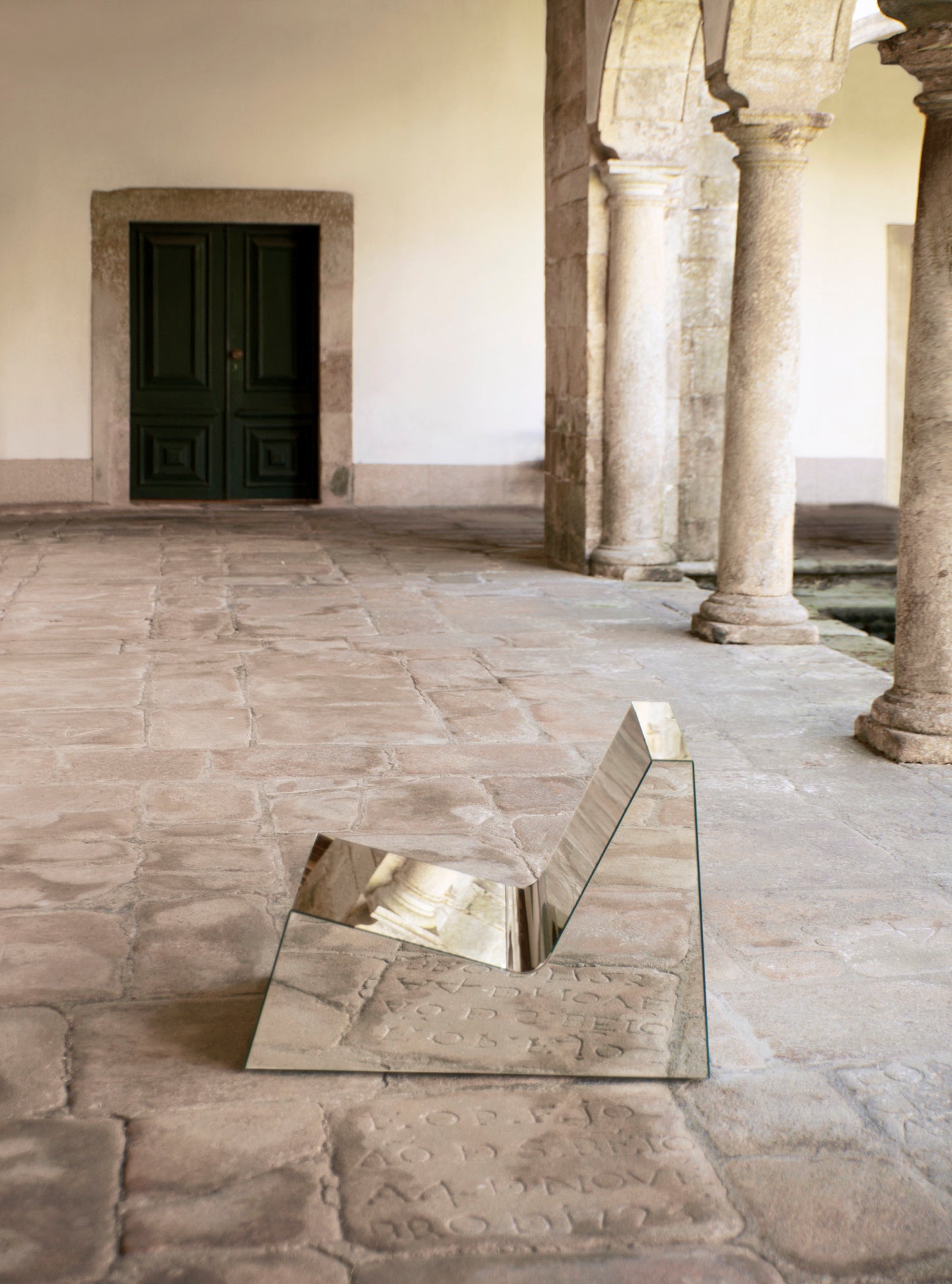 Discover a modern chair with a minimalist design, featuring a reflective mirror surface. Its angular shape creates a geometric aesthetic, set against a plain white background. This stunning piece of furniture is available for sale by The Graduate Gallery.