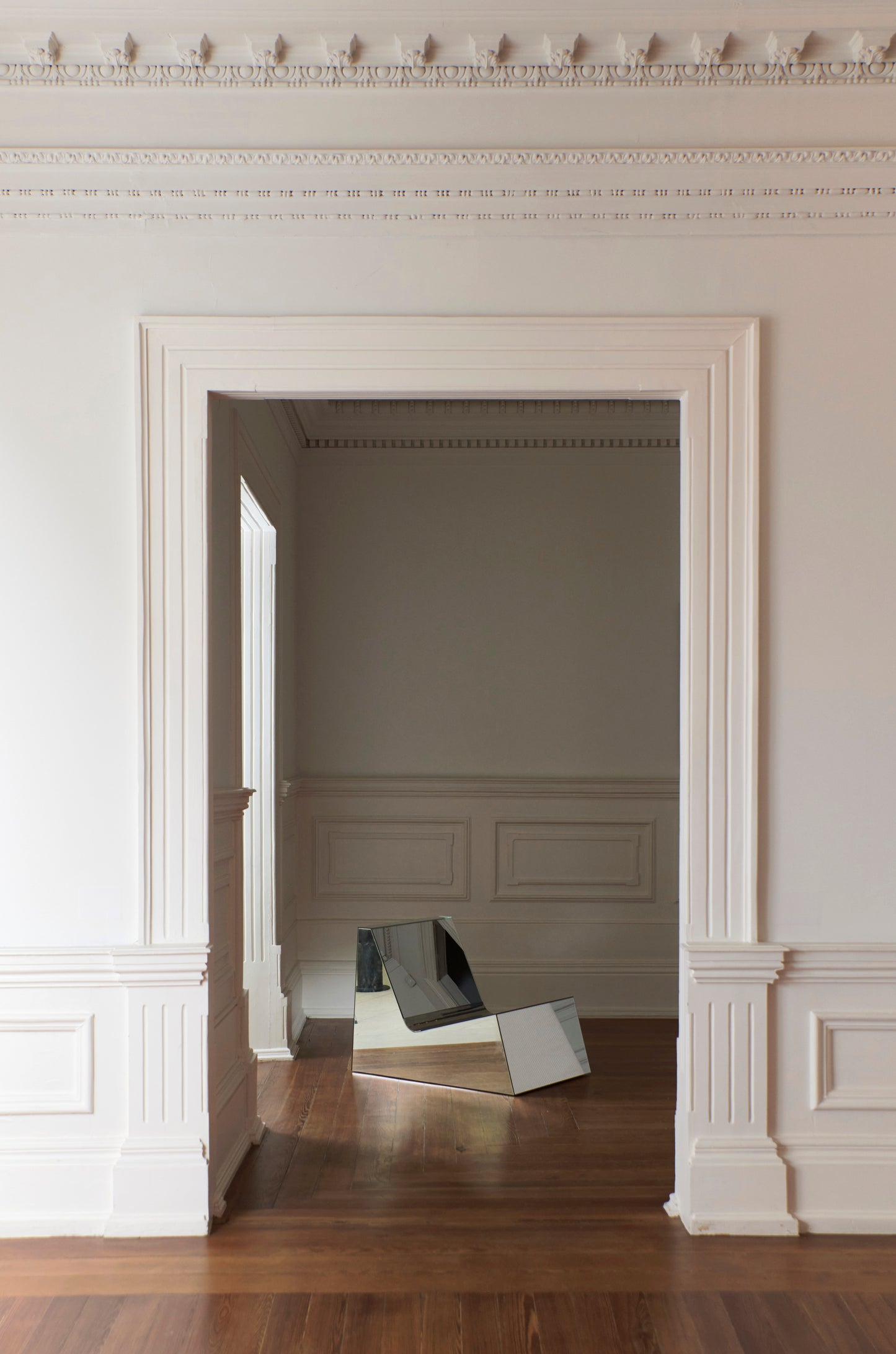 Discover a modern chair with a minimalist design, featuring a reflective mirror surface. Its angular shape creates a geometric aesthetic, set against a plain white background. This stunning piece of furniture is available for sale by The Graduate Gallery.