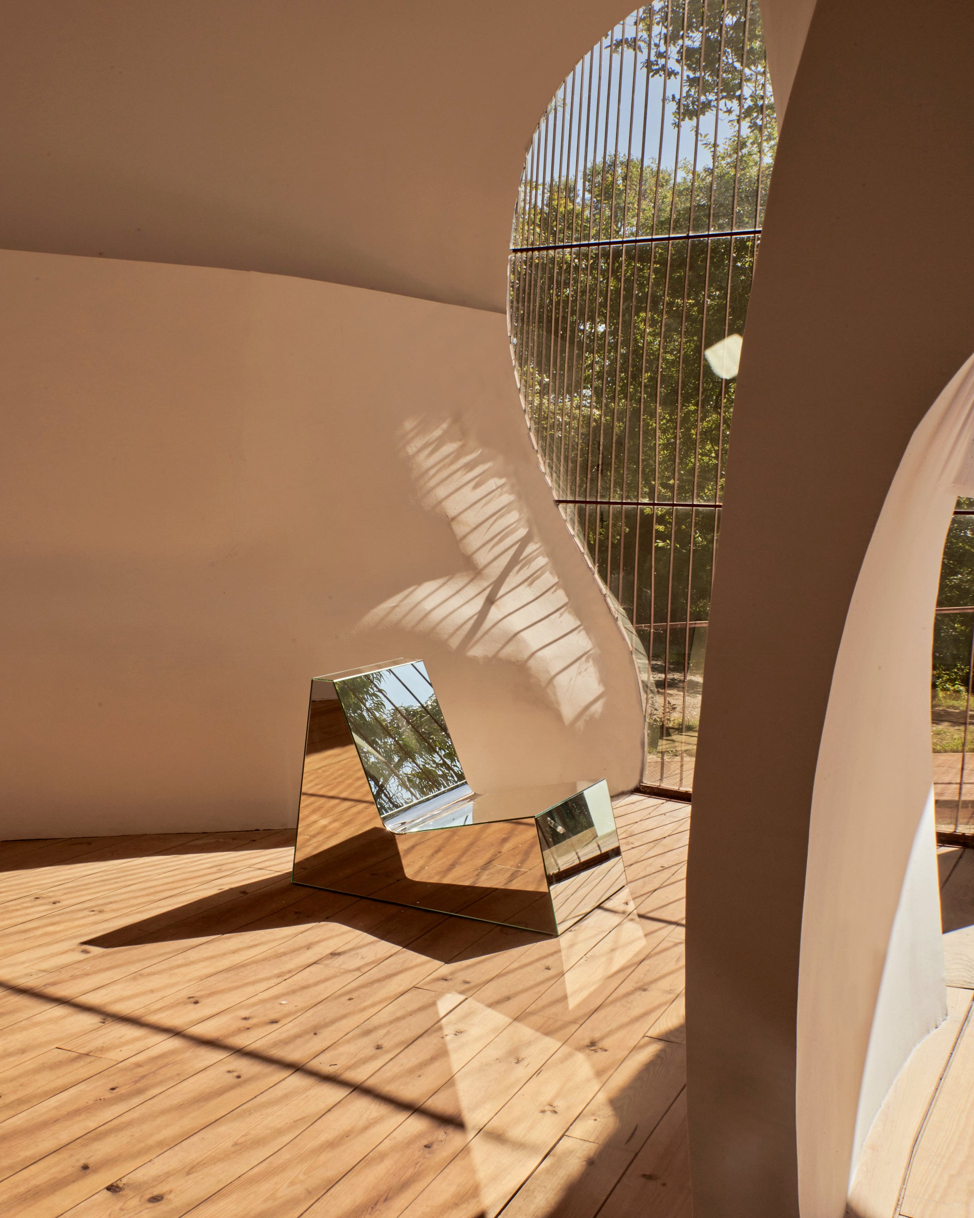 Discover a modern chair with a minimalist design, featuring a reflective mirror surface. Its angular shape creates a geometric aesthetic, set against a plain white background. This stunning piece of furniture is available for sale by The Graduate Gallery.
