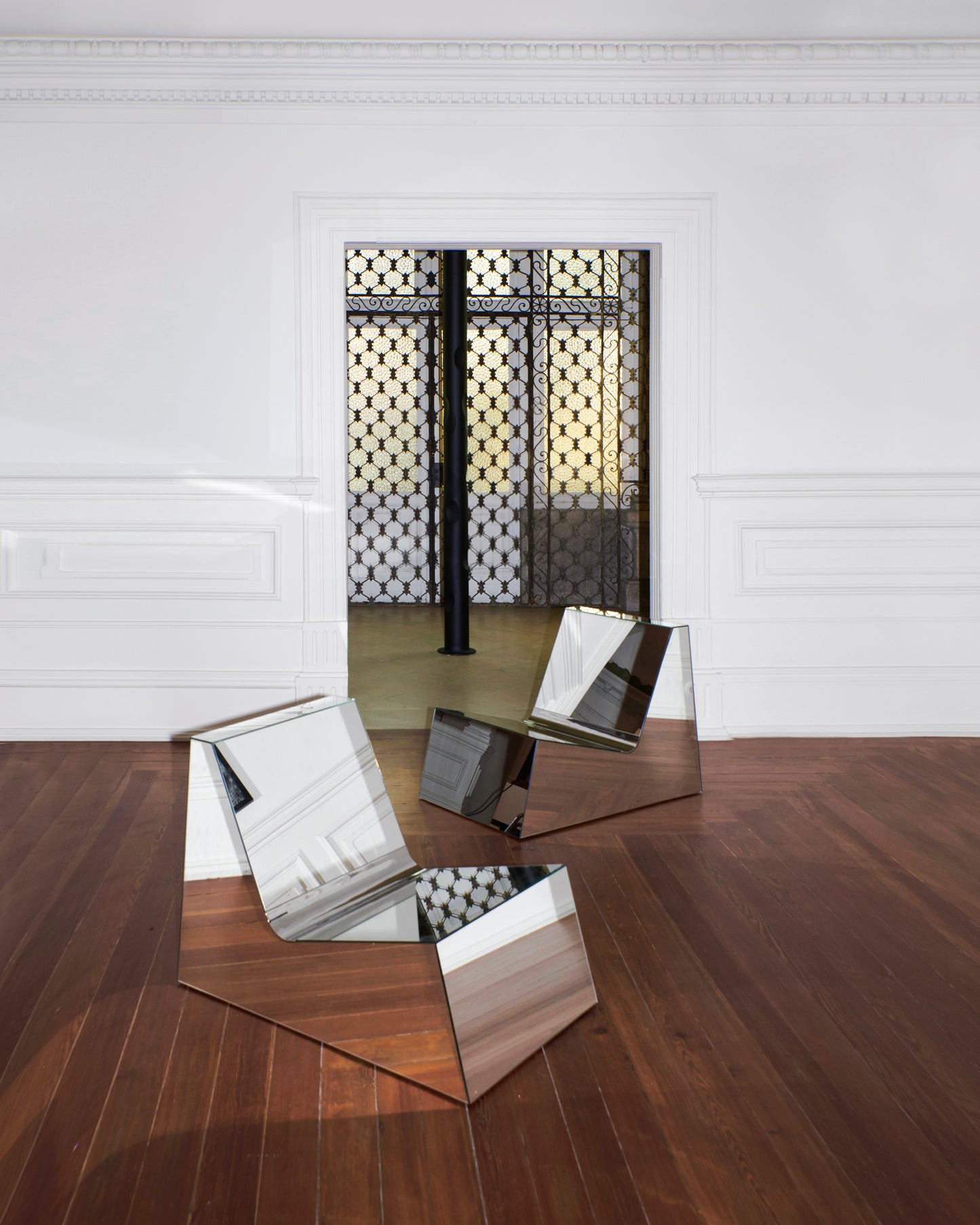 Discover a modern chair with a minimalist design, featuring a reflective mirror surface. Its angular shape creates a geometric aesthetic, set against a plain white background. This stunning piece of furniture is available for sale by The Graduate Gallery.