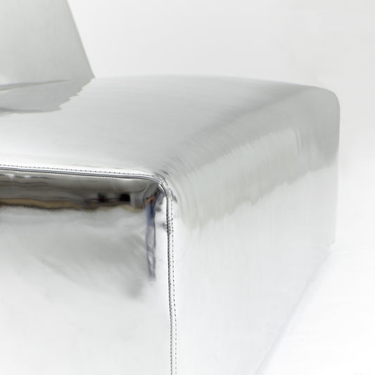 A modern, metallic couch from Project 213A a European design house launched in 2021, boasts a shiny silver finish and angular design.