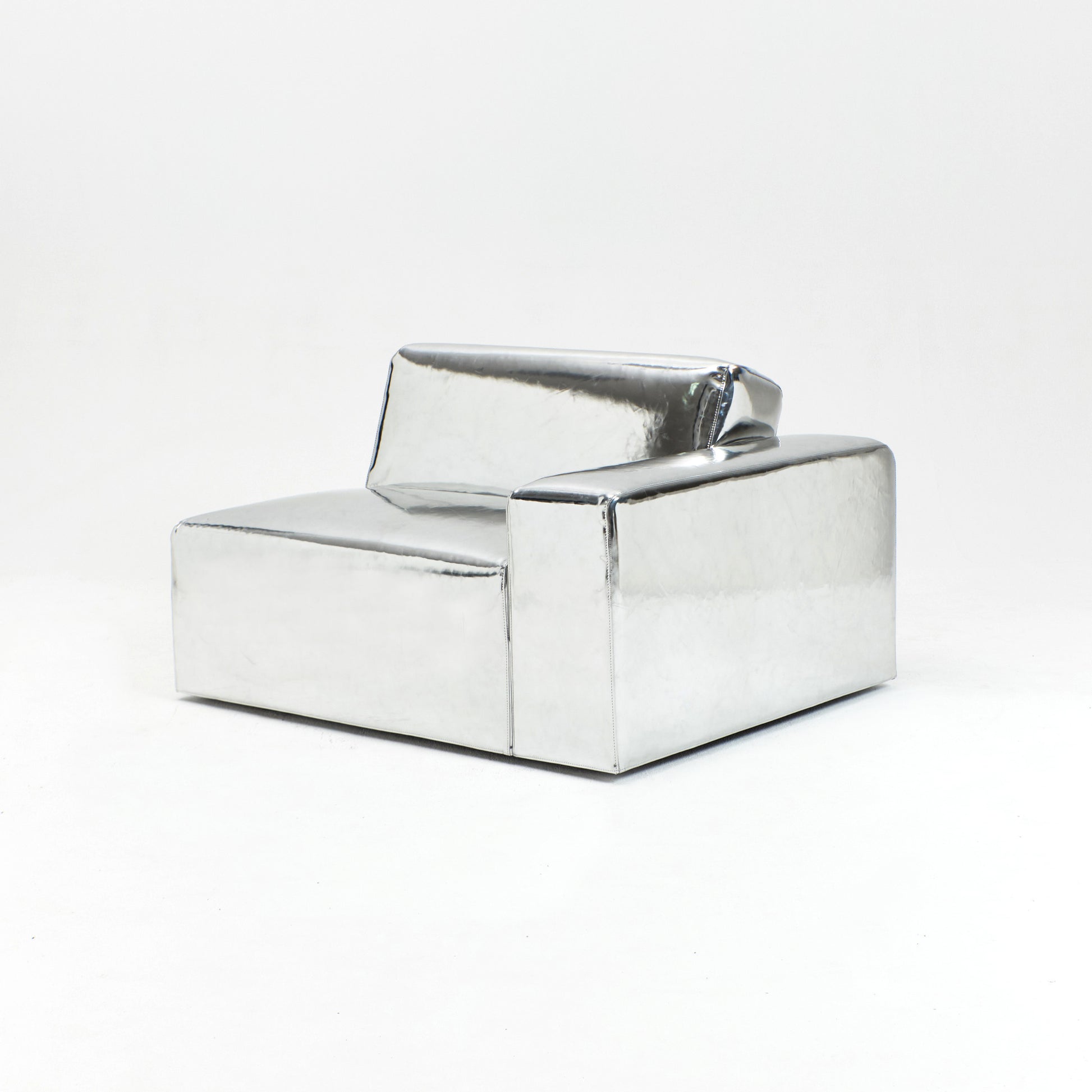 A modern, metallic couch from Project 213A a European design house launched in 2021, boasts a shiny silver finish and angular design.