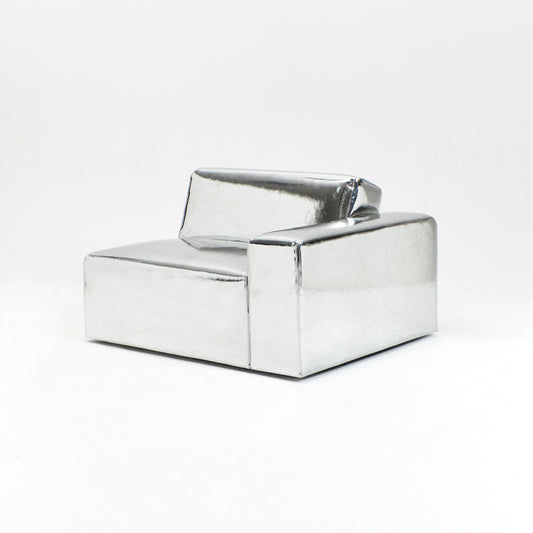 A modern, metallic couch from Project 213A a European design house launched in 2021, boasts a shiny silver finish and angular design.