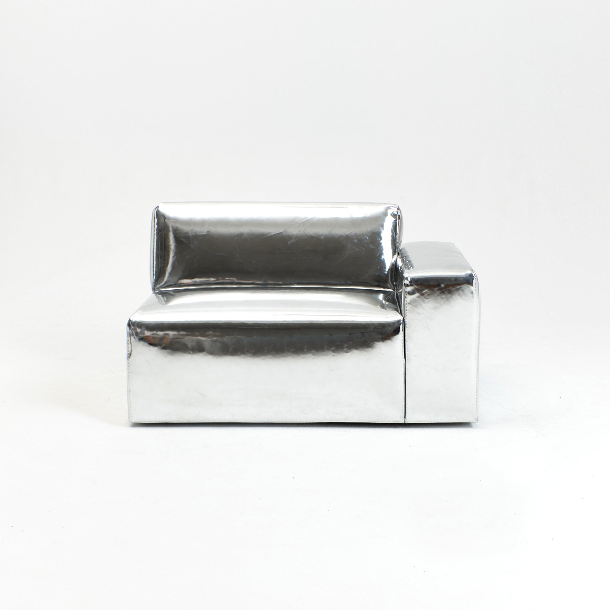 A modern, metallic couch from Project 213A a European design house launched in 2021, boasts a shiny silver finish and angular design.