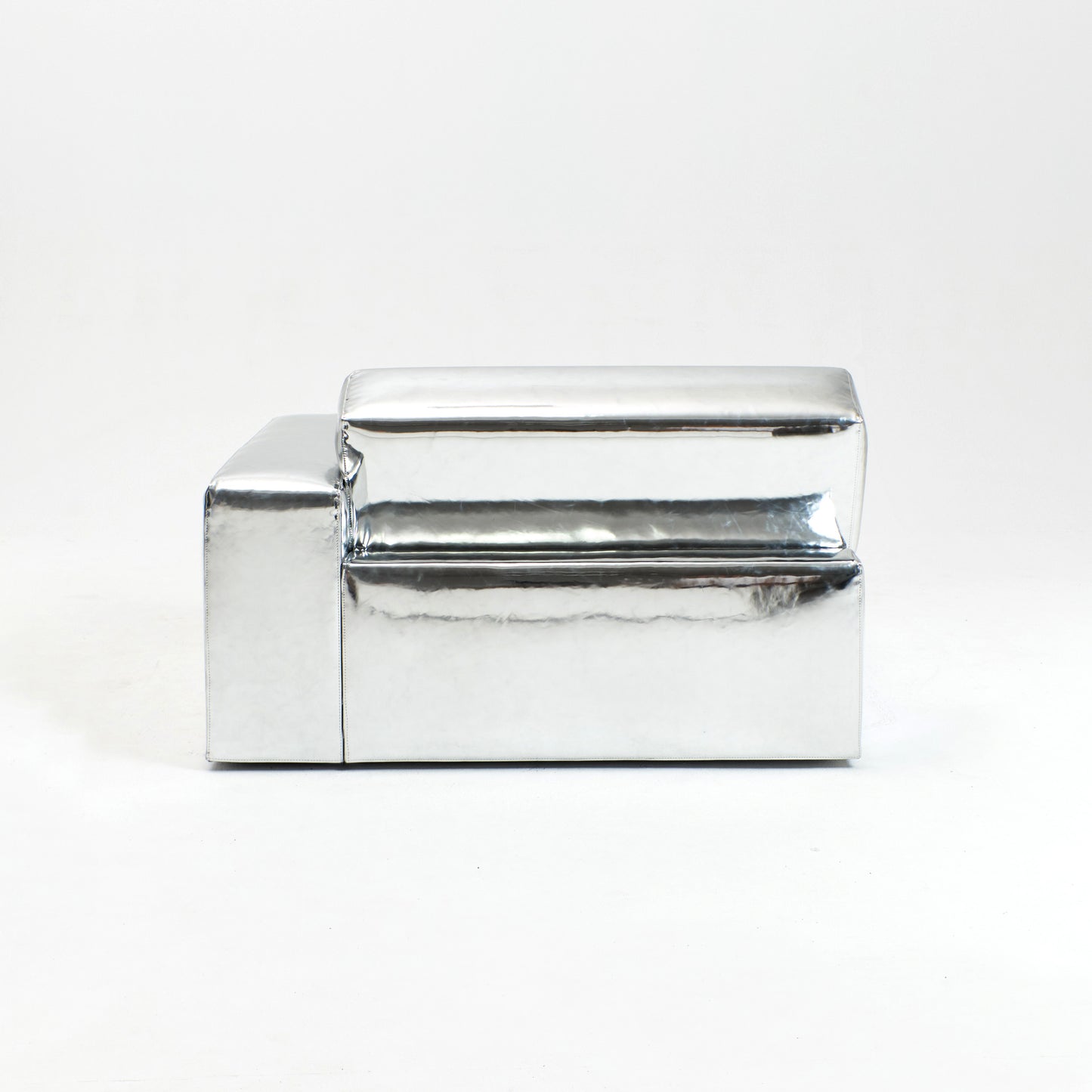 A modern, metallic couch from Project 213A a European design house launched in 2021, boasts a shiny silver finish and angular design.