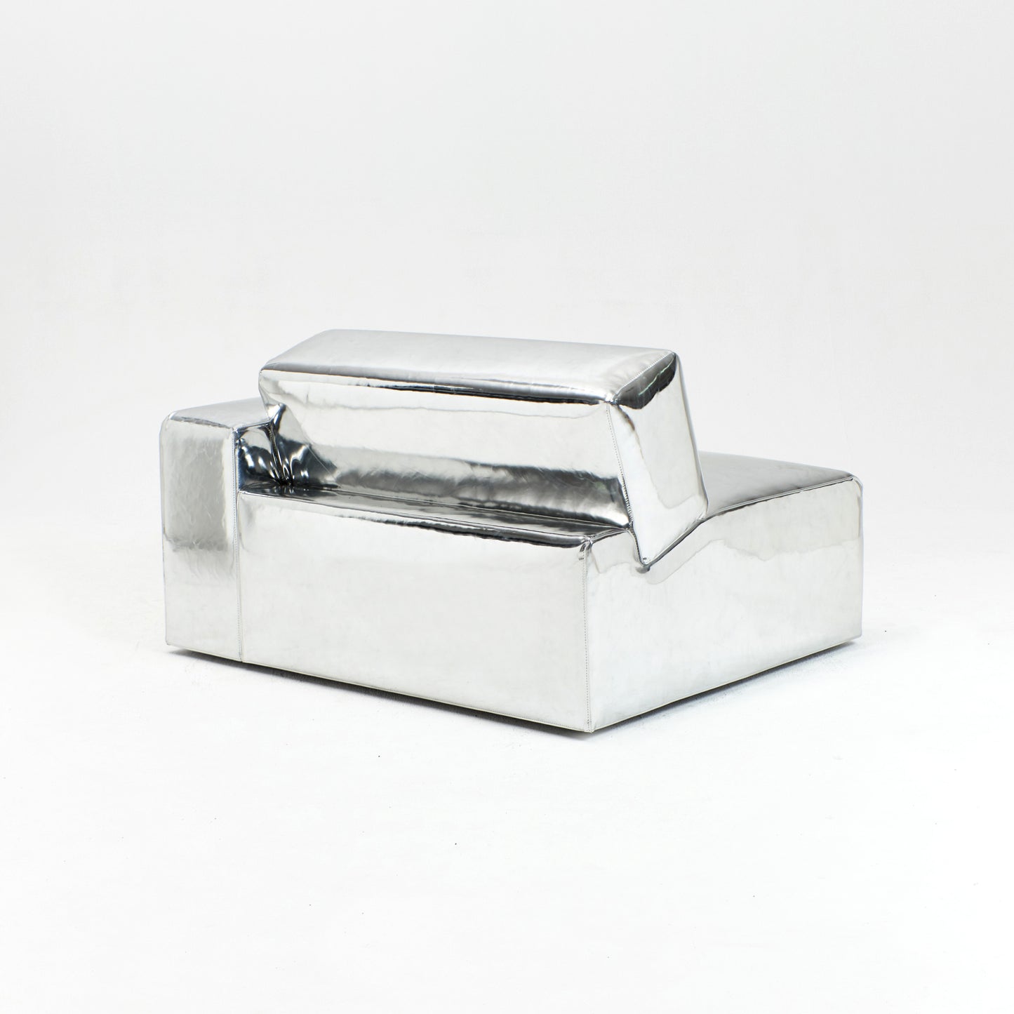 A modern, metallic couch from Project 213A a European design house launched in 2021, boasts a shiny silver finish and angular design.