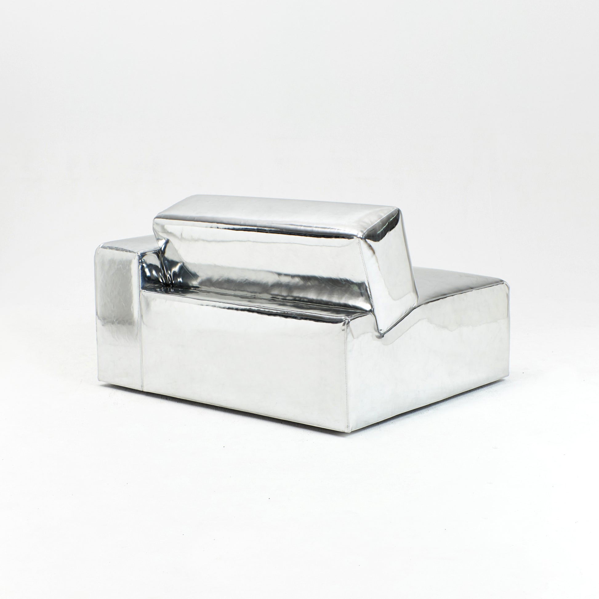 A modern, metallic couch from Project 213A a European design house launched in 2021, boasts a shiny silver finish and angular design.