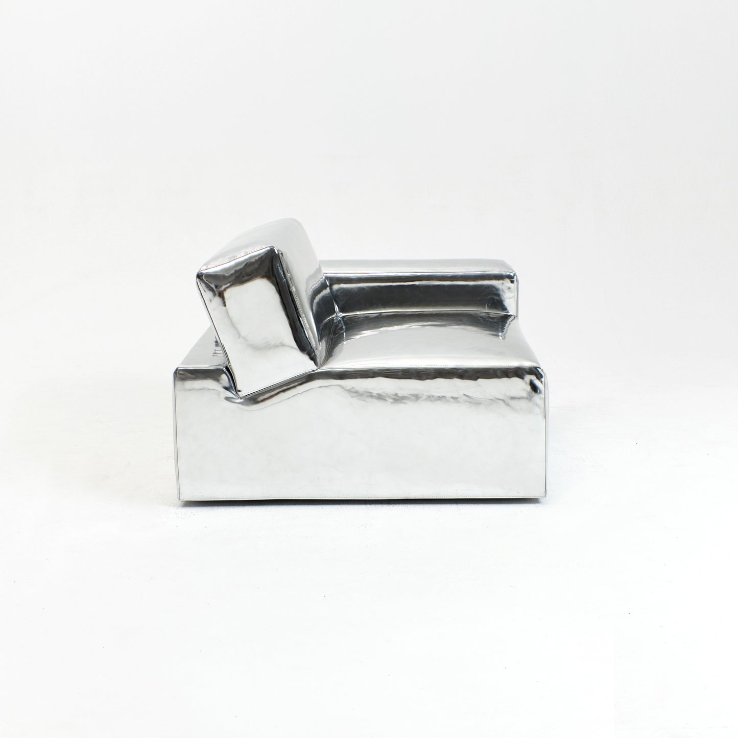 A modern, metallic couch from Project 213A a European design house launched in 2021, boasts a shiny silver finish and angular design.