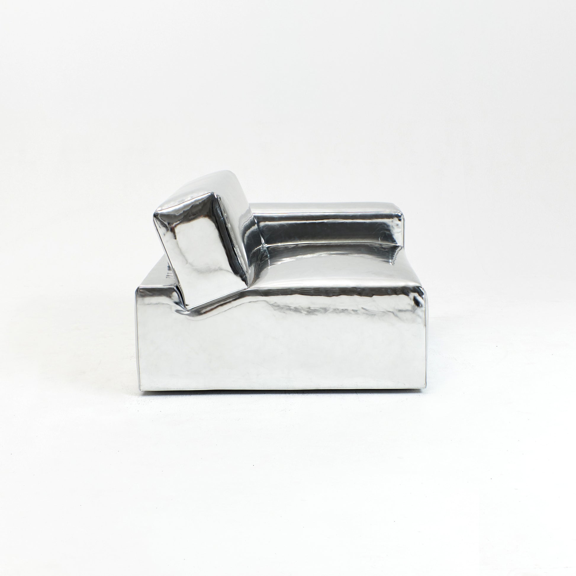 A modern, metallic couch from Project 213A a European design house launched in 2021, boasts a shiny silver finish and angular design.