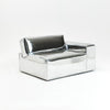 A modern, metallic couch from Project 213A a European design house launched in 2021, boasts a shiny silver finish and angular design.
