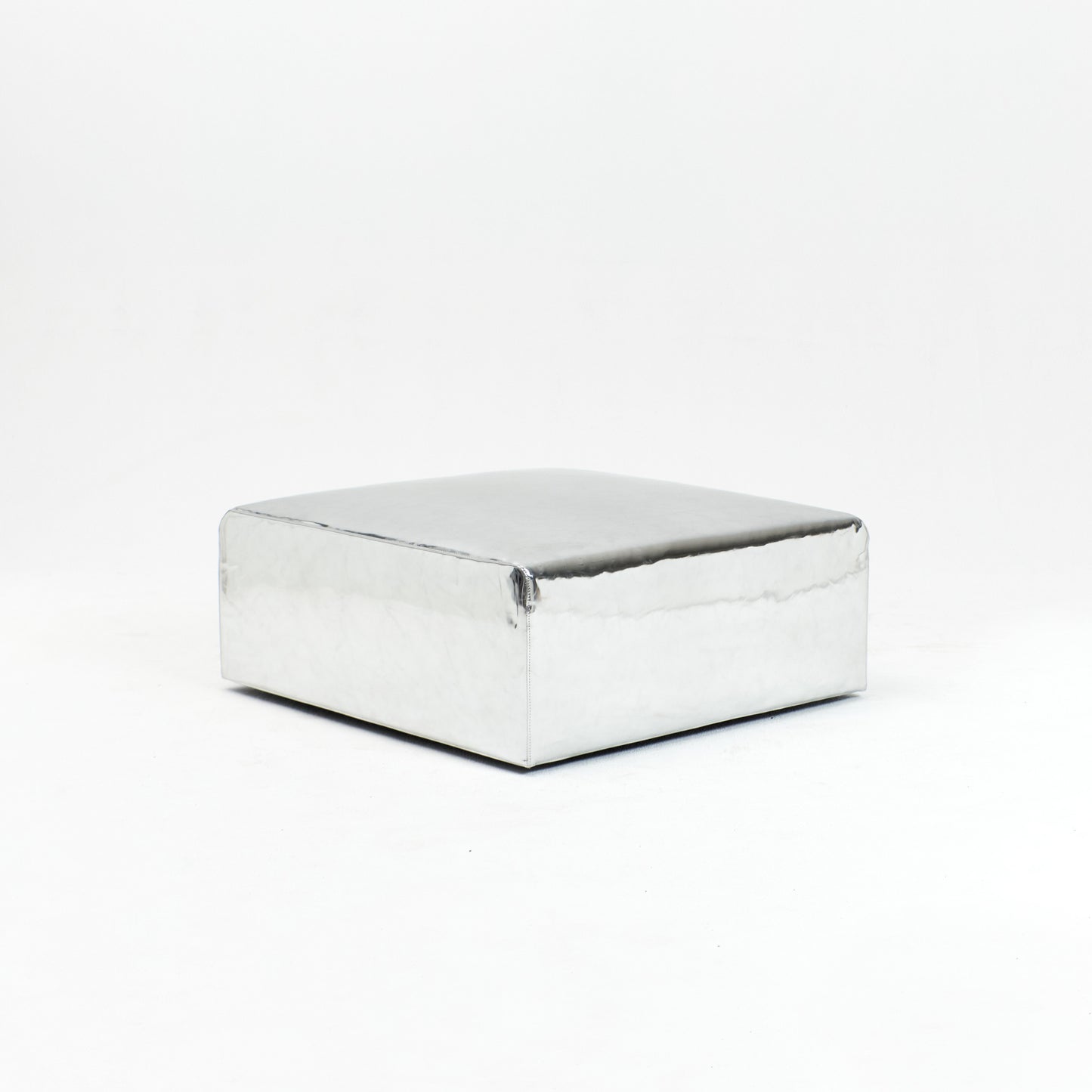 A modern, metallic couch from Project 213A a European design house launched in 2021, boasts a shiny silver finish and angular design.