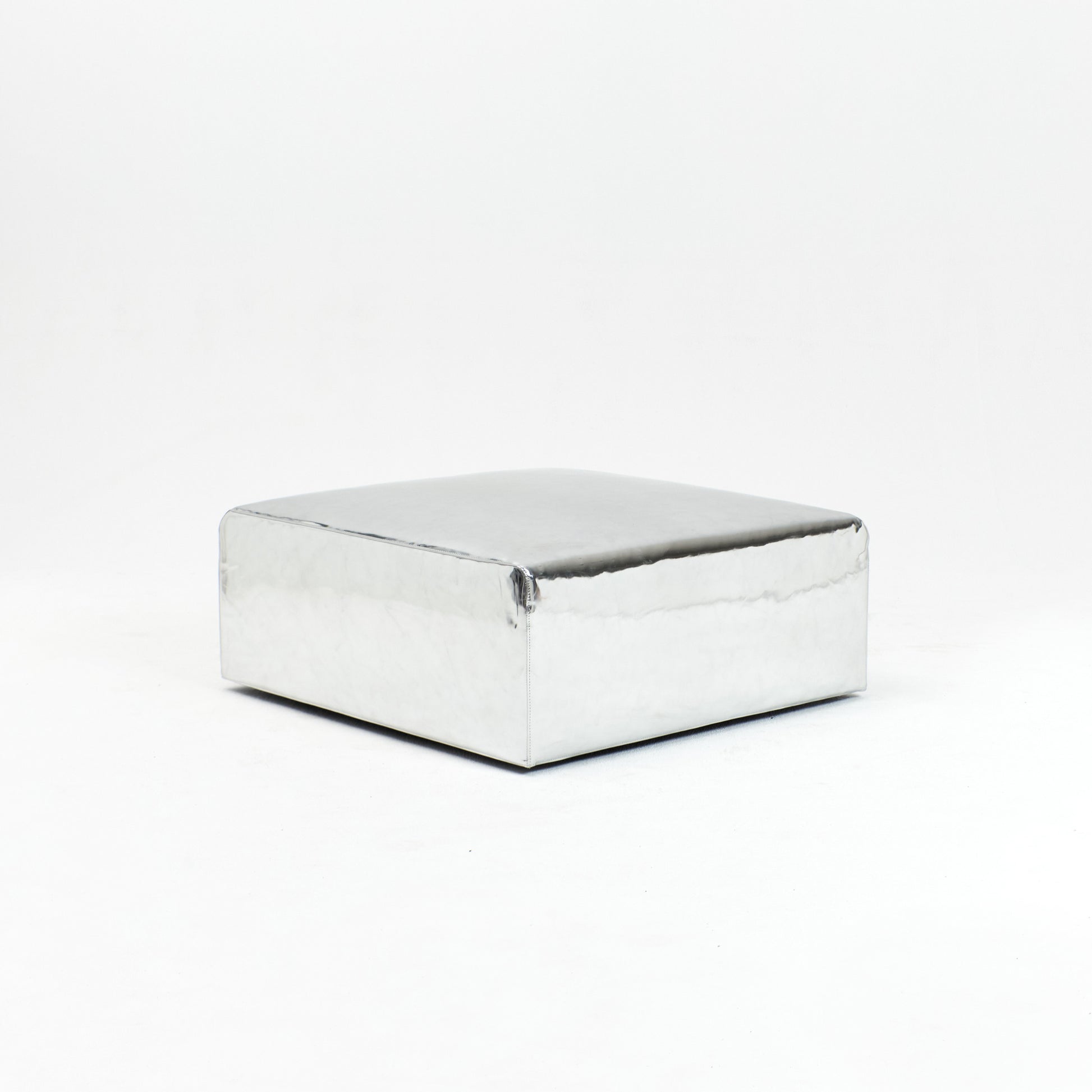 A modern, metallic couch from Project 213A a European design house launched in 2021, boasts a shiny silver finish and angular design.