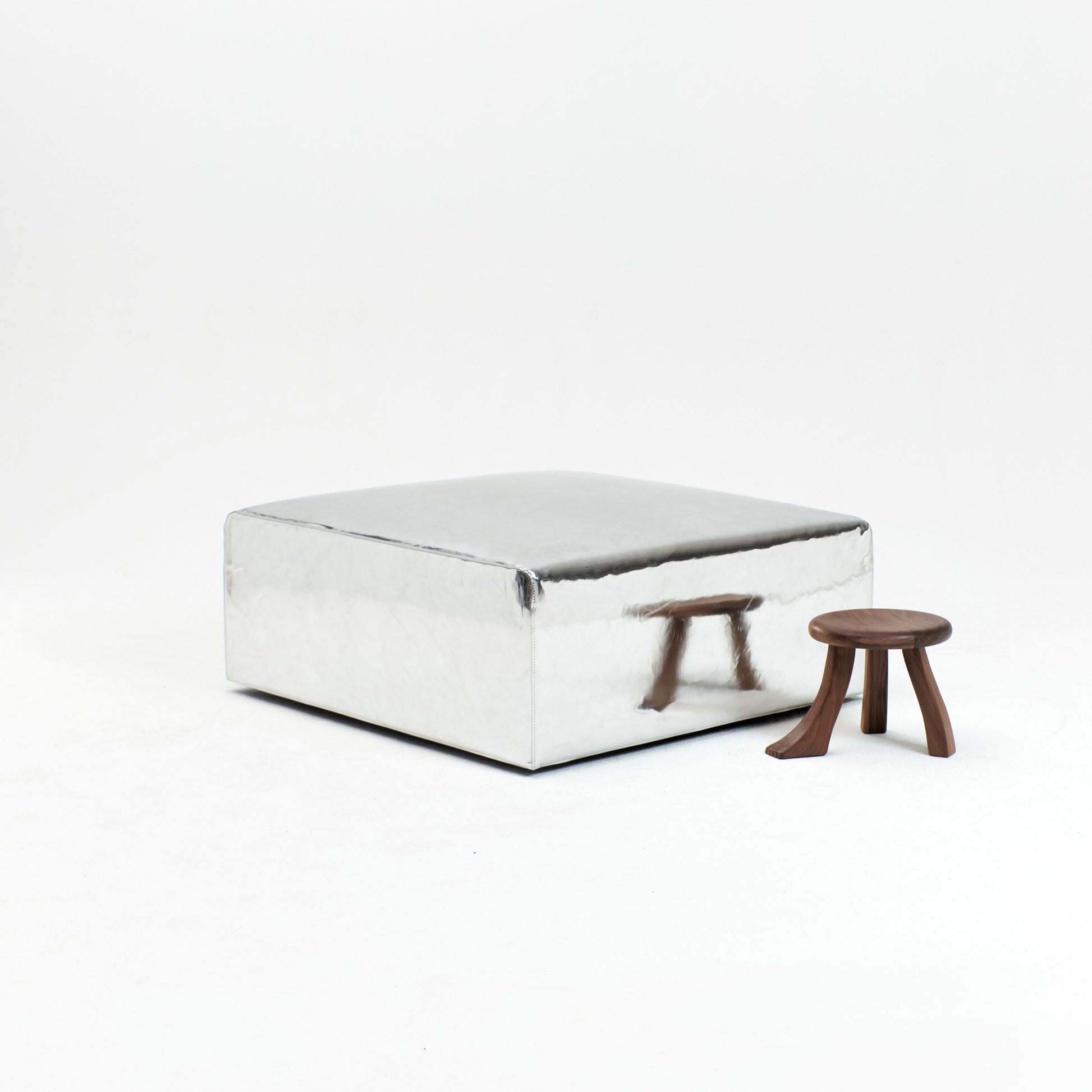 A modern, metallic couch from Project 213A a European design house launched in 2021, boasts a shiny silver finish and angular design.
