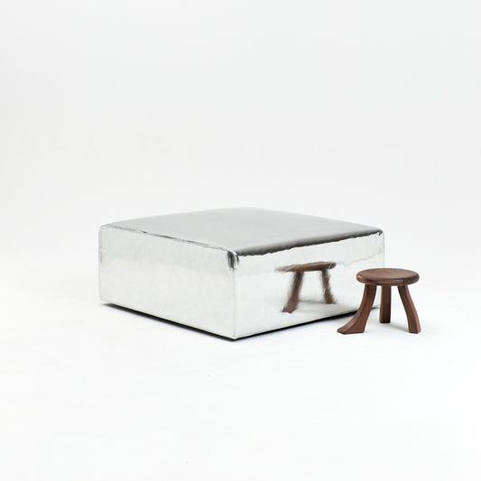 A modern, metallic couch from Project 213A a European design house launched in 2021, boasts a shiny silver finish and angular design.