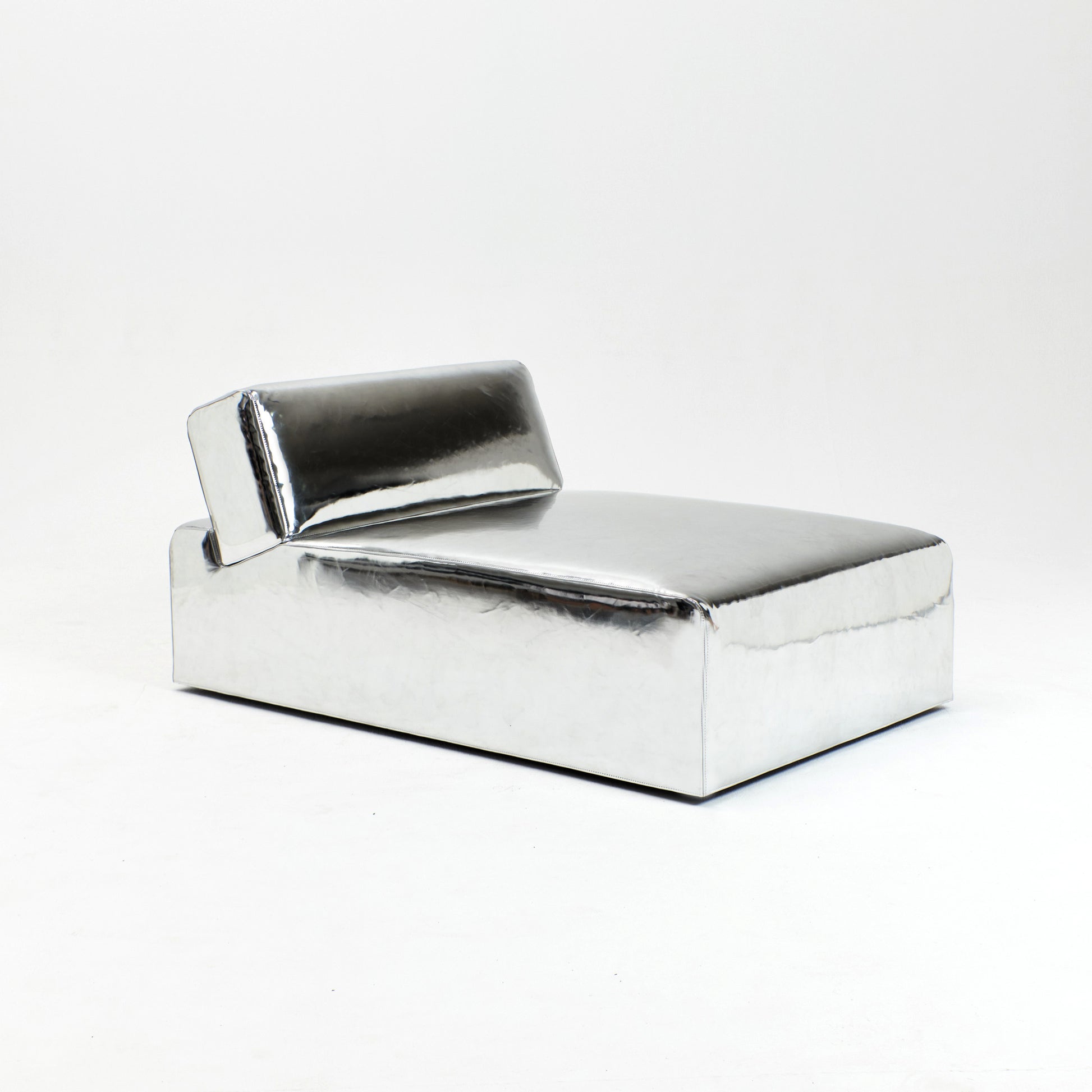 A modern, metallic couch from Project 213A a European design house launched in 2021, boasts a shiny silver finish and angular design.