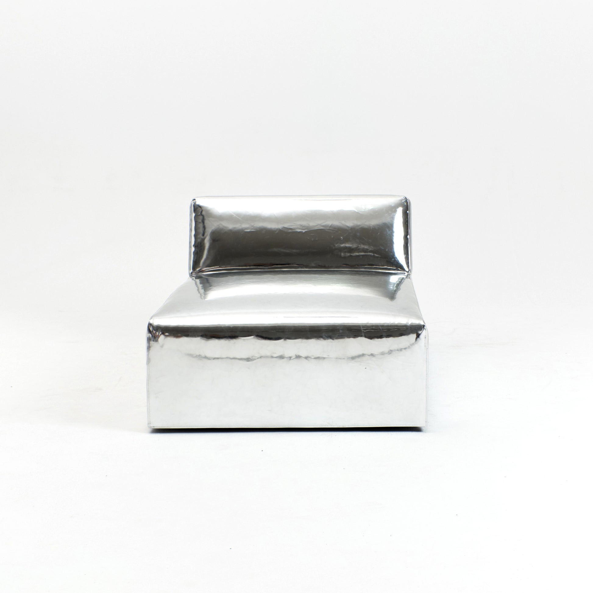 A modern, metallic couch from Project 213A a European design house launched in 2021, boasts a shiny silver finish and angular design.