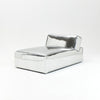 A modern, metallic couch from Project 213A a European design house launched in 2021, boasts a shiny silver finish and angular design. With its rectangular backrest, this piece of furniture stands elegantly against a plain white background.