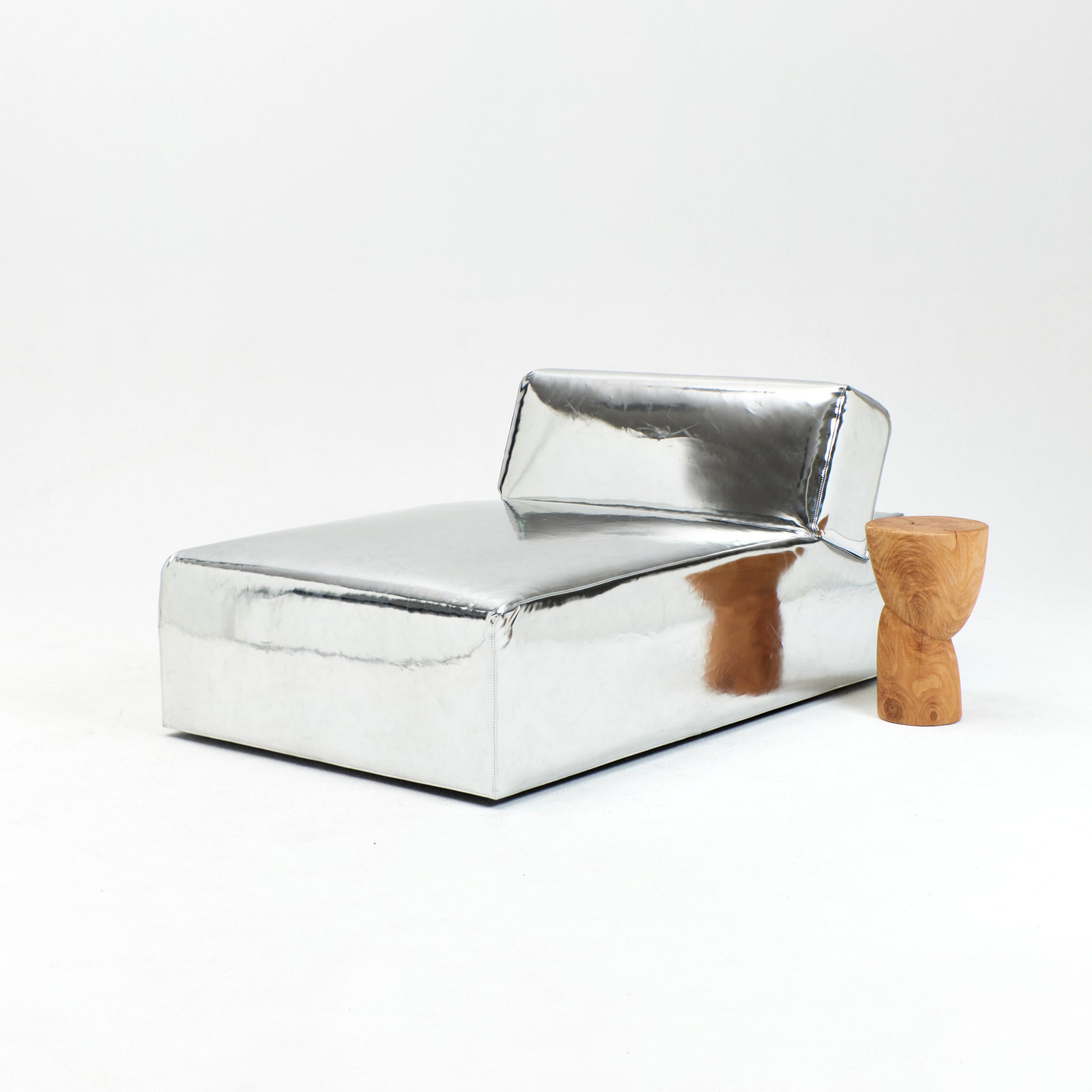 A modern, metallic couch from Project 213A a European design house launched in 2021, boasts a shiny silver finish and angular design.