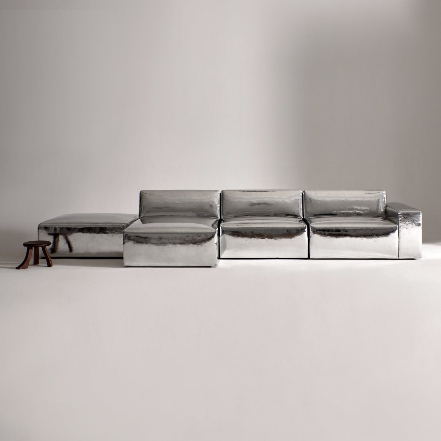 A modern, metallic couch from Project 213A a European design house launched in 2021, boasts a shiny silver finish and angular design.