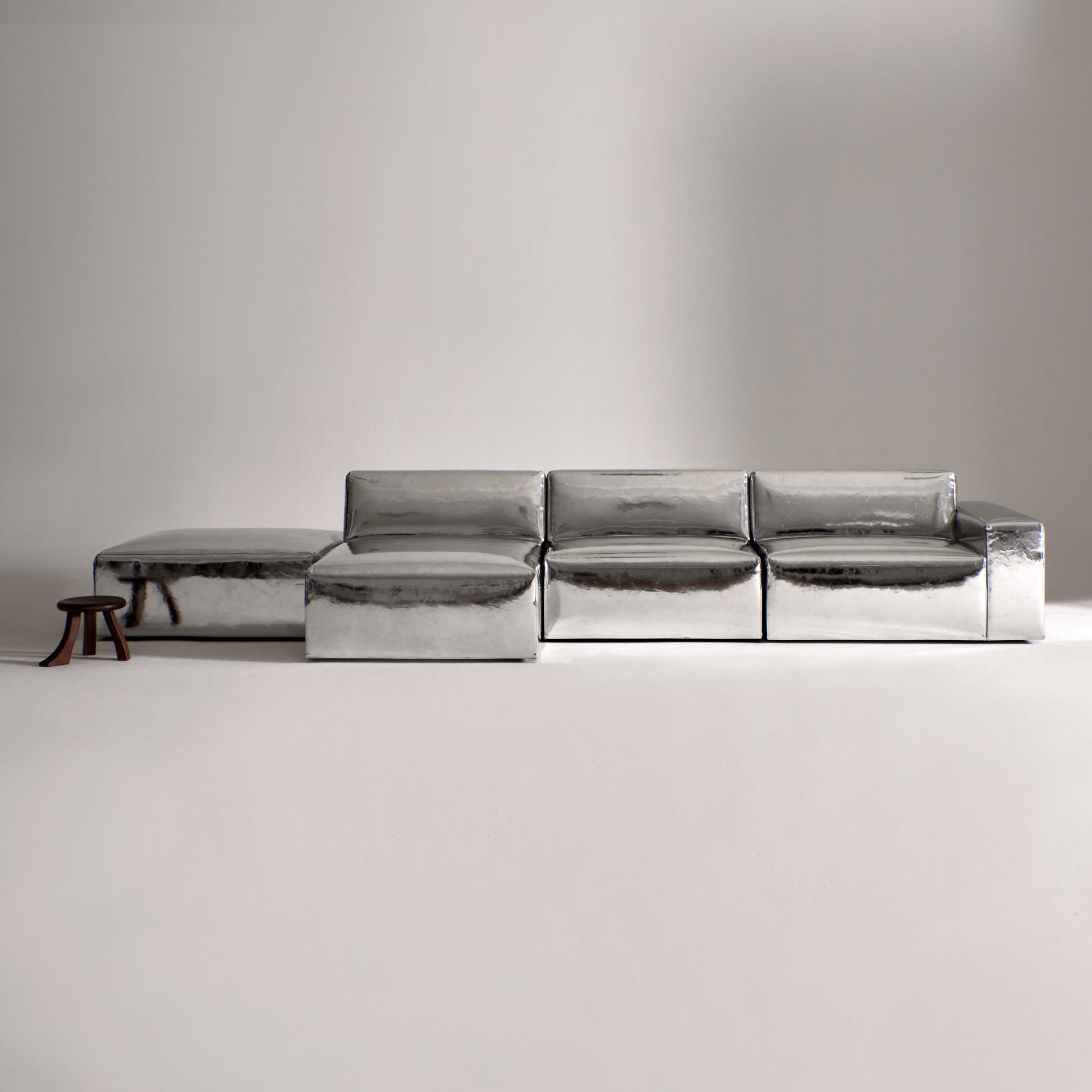 A modern, metallic couch from Project 213A a European design house launched in 2021, boasts a shiny silver finish and angular design.