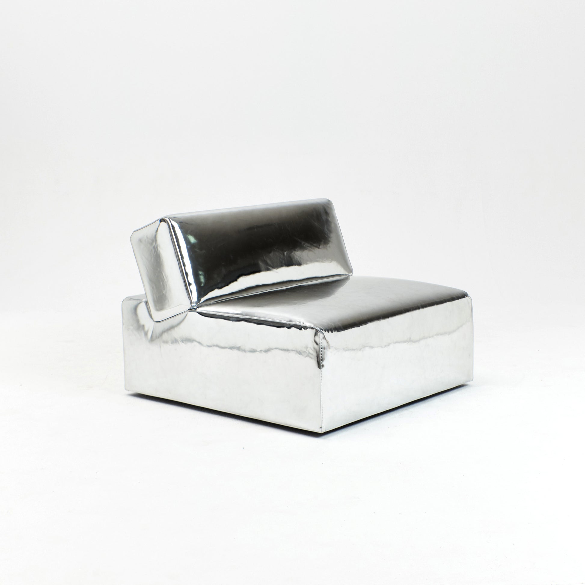A modern, metallic couch from Project 213A a European design house launched in 2021, boasts a shiny silver finish and angular design.