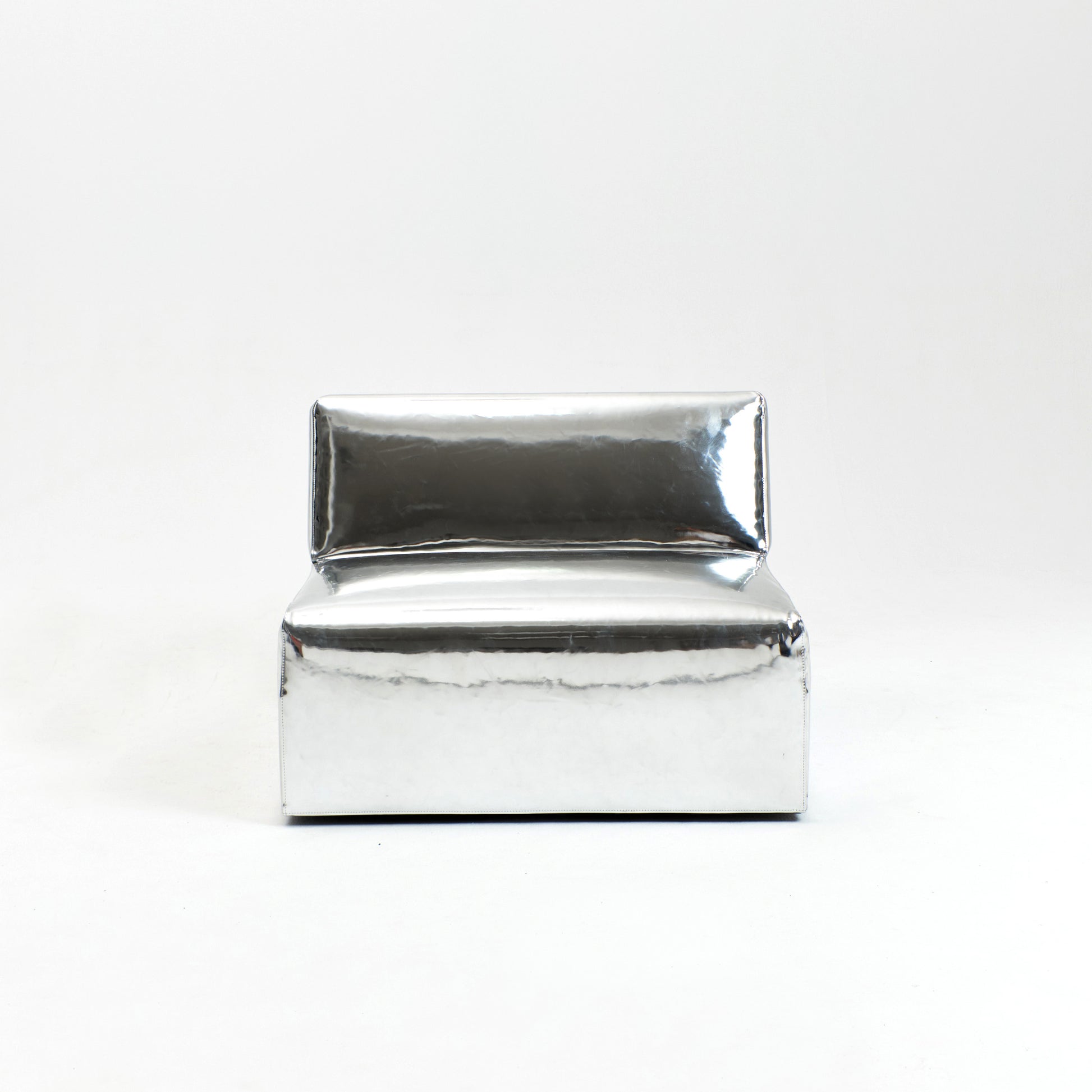 A modern, metallic couch from Project 213A a European design house launched in 2021, boasts a shiny silver finish and angular design.
