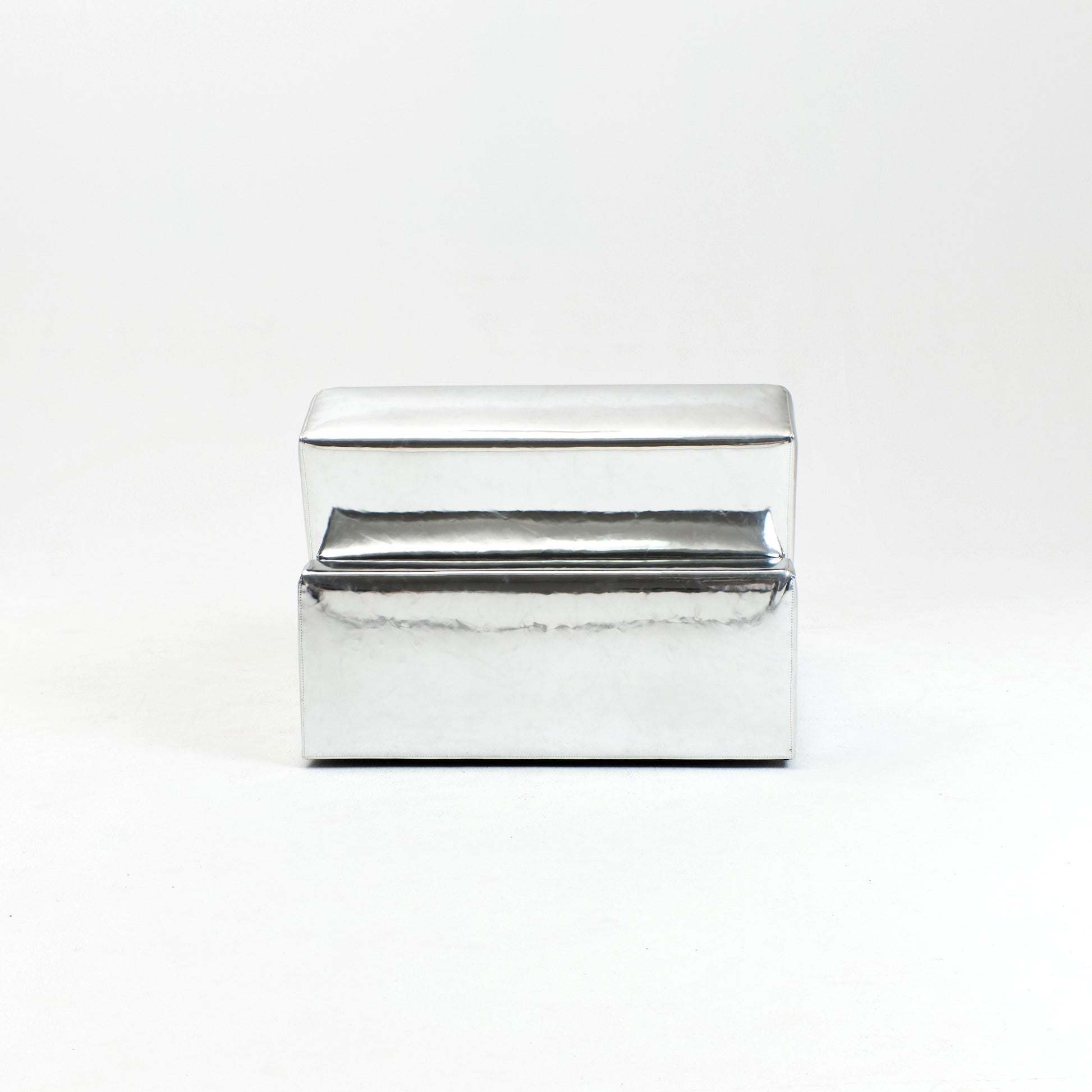 A modern, metallic couch from Project 213A a European design house launched in 2021, boasts a shiny silver finish and angular design.