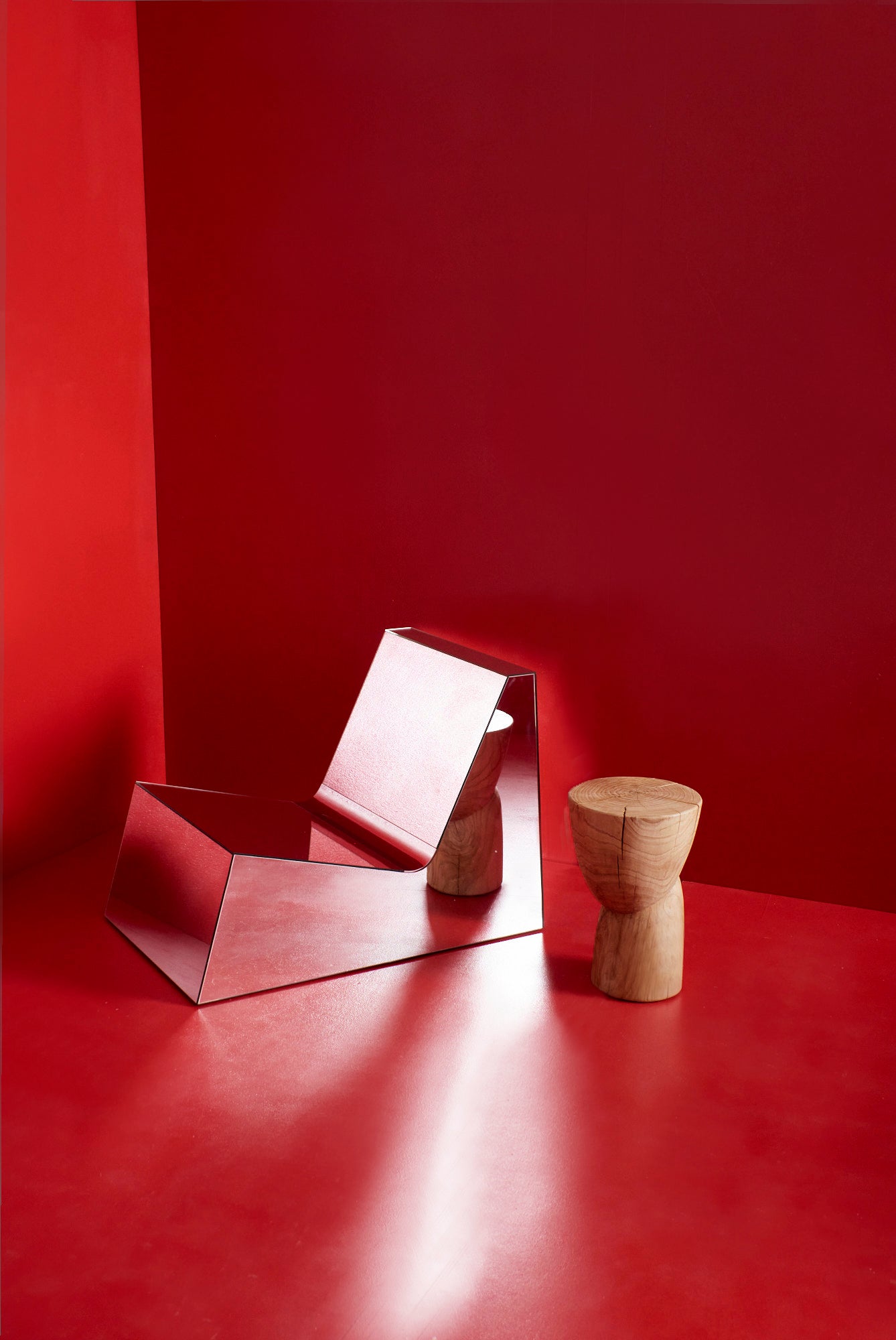 Discover a modern chair with a minimalist design, featuring a reflective mirror surface. Its angular shape creates a geometric aesthetic, set against a plain white background. This stunning piece of furniture is available for sale by The Graduate Gallery.
