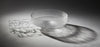 A circular, translucent gray glasswork bowl, crafted by a graduate artist in the UK, rests elegantly on a geometric wireframe base. This intricate network of lines and nodes casts delicate shadows below, reflecting the innovative artworks for sale at The Graduate Gallery.