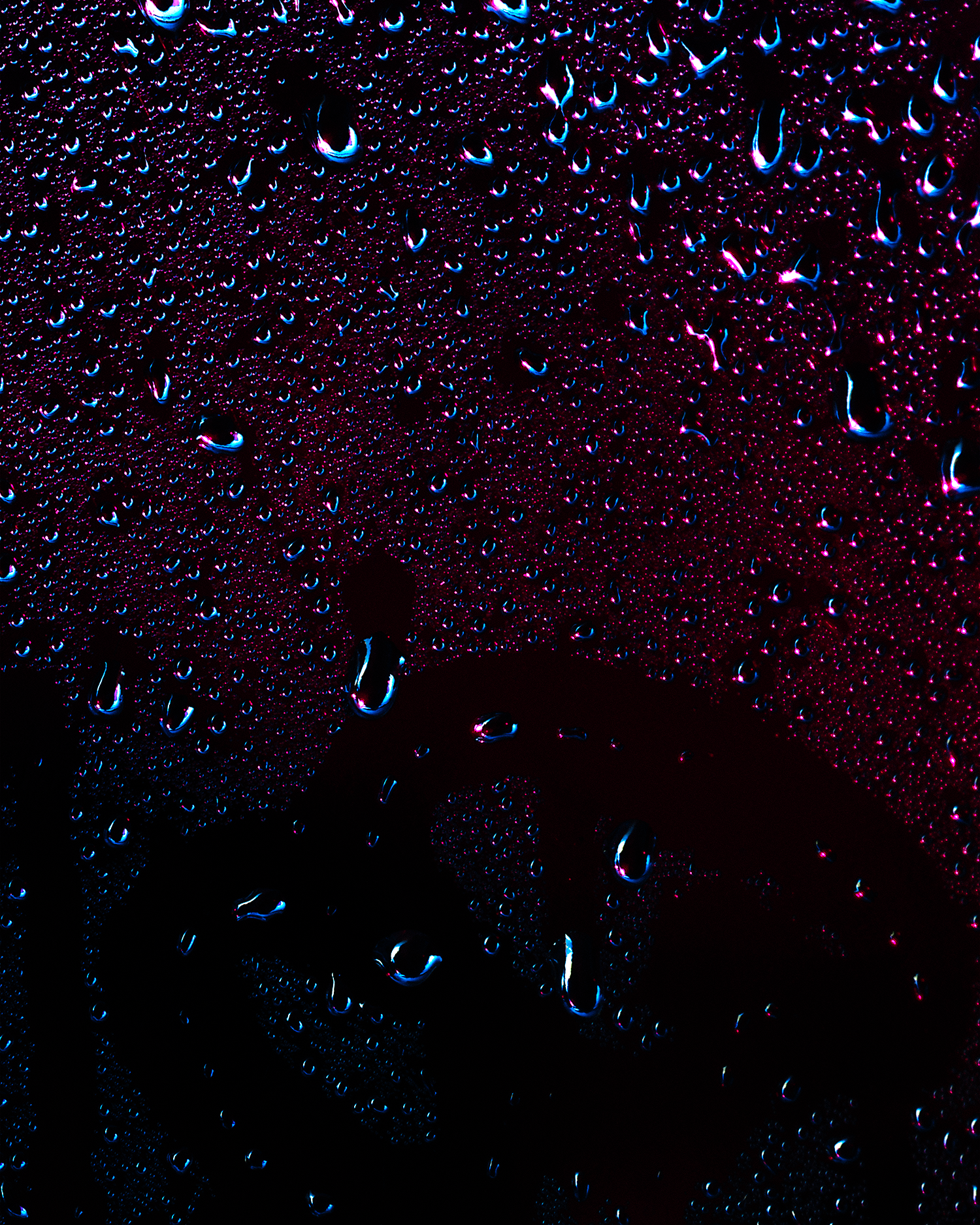 A graduate artwork by Joel Dixon, presented with The Graduate Gallery. The piece features a dark, textured surface adorned with glistening water droplets, set against deep hues of black, purple, and red. The abstract composition evokes a moody, atmospheric tone, with the droplets adding a sense of depth and tactile contrast. Displayed on a minimal white gallery wall, the work draws attention to its intricate details and reflective surface.