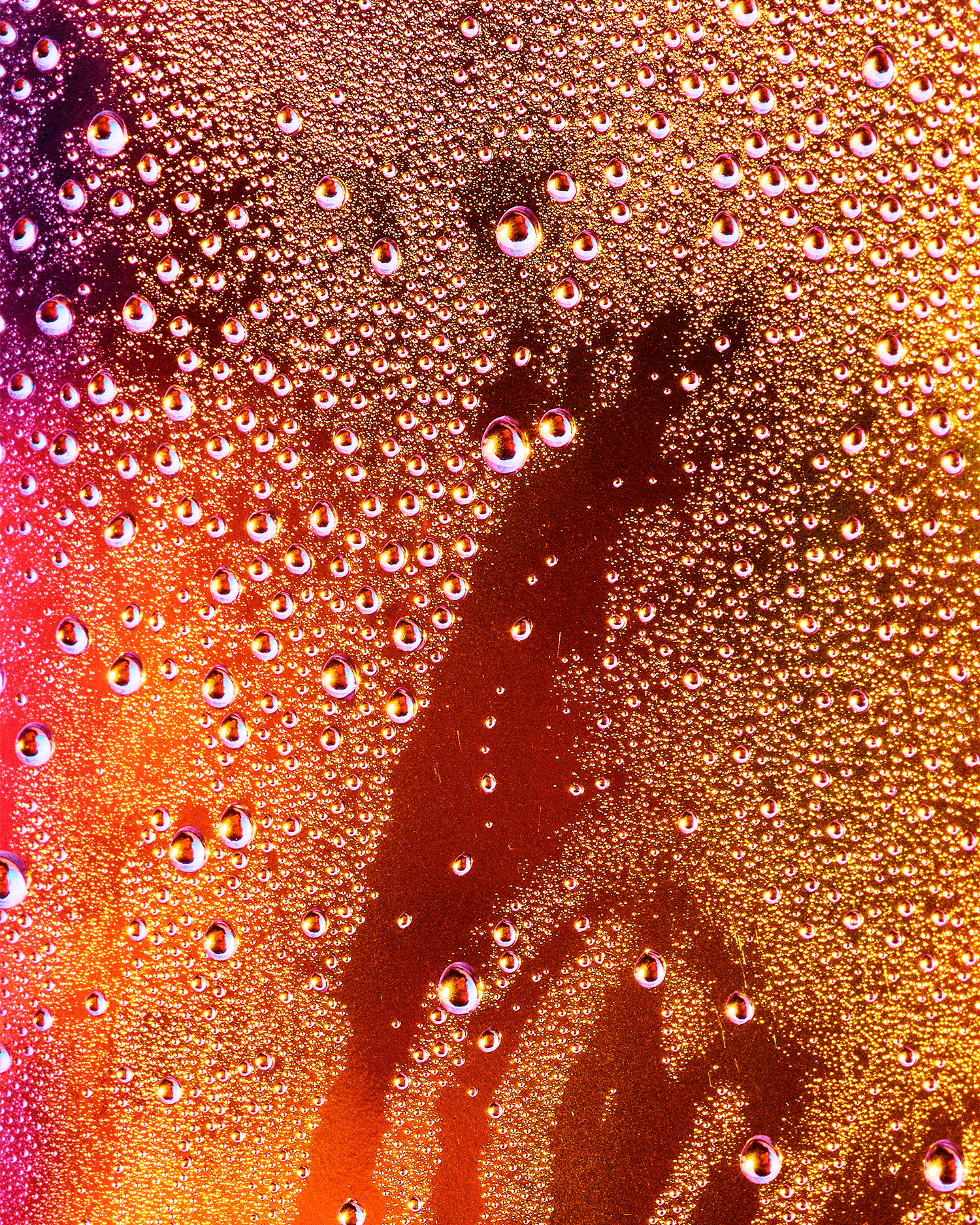 Joel Dixon, a graduate artist in the UK captures a close-up of condensation droplets on a glass surface, where vibrant orange and yellow lighting create an abstract pattern. This mesmerizing piece is part of the graduate artworks for sale by The Graduate Gallery.