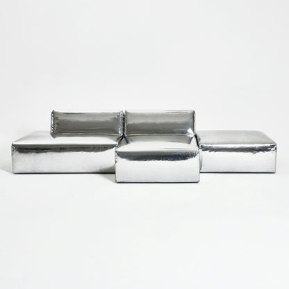 A modern, metallic couch from Project 213A a European design house launched in 2021, boasts a shiny silver finish and angular design. 